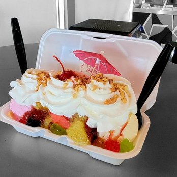 Tropical fruit boat with whipped cream and umbrella