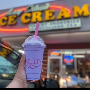 Taro smoothie held in front of the storefront